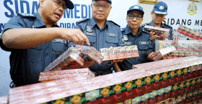 HASIL RAMPASAN: Zulkifli (tengah) menunjukkan sebahagian daripada 8.98 juta batang rokok jenama ‘SAAT’ membabitkan nilai cukai RM7 juta yang dirampas dari sebuah kapal kargo ketika mengadakan sidang media di Seremban semalam. — Gambar Bernama