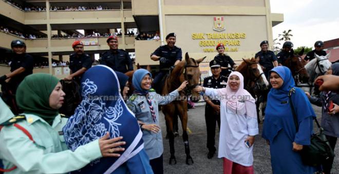 KONGSI MAKLUMAT: Zulkifli (berkuda, tengah) beramah mesra bersama Zainab (tiga kanan) sempena Program Komuniti Polisi di sekolah, Kuala Lumpur, semalam. — Gambar Bernama
