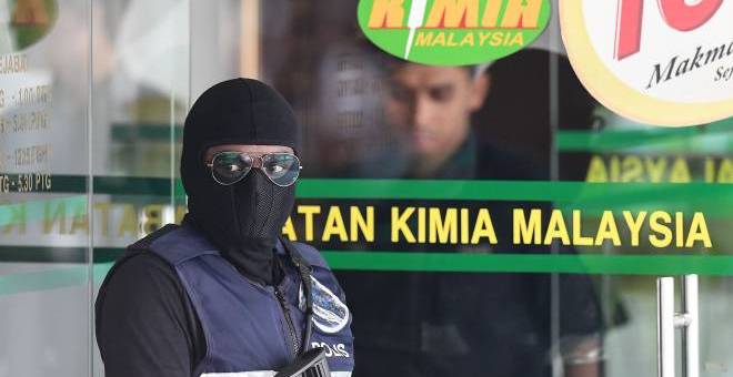 Pegawai Polis DiRaja Malaysia (PDRM) mengawasi pintu masuk utama Jabata Kimia Malaysia berikutan kedatangan tertuduh warganegara Indonesia, Siti Aisyah dan Vietnam, Doan Thi Huong ke premis itu di Petaling Jaya, Kuala Lumpur hari ini, sebagai sebahagian daripada perbicaraan untuk dua wanita yang terbabit dalam pembunuhan Kim Jong-nam. Kedua-dua tertuduh dibawa ke jabatan untuk melihat pakaian yang dikatakan tercemar dengan agen saraf dan bahan kimia lain yang digunakan untuk membunuh Kim. - Foto AFP