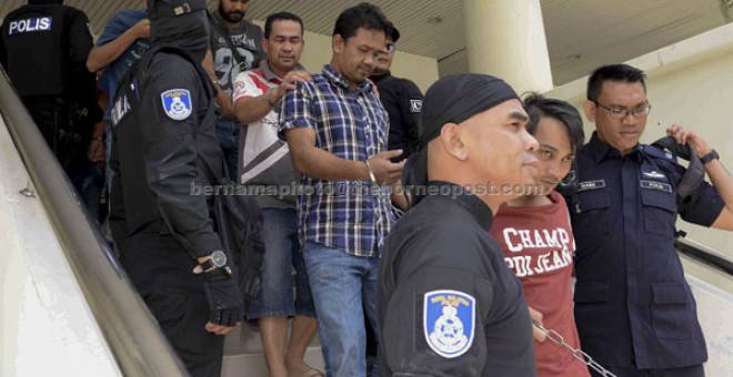 DITAHAN: Anggota polis membawa sebahagian daripada 20 anggota Geng Pak Su di Mahkamah Sesyen dekat Alor Setar, semalam kerana terbabit dalam aktiviti penyeludupan di sekitar sempadan Malaysia-Thailand. — Gambnar Bernama