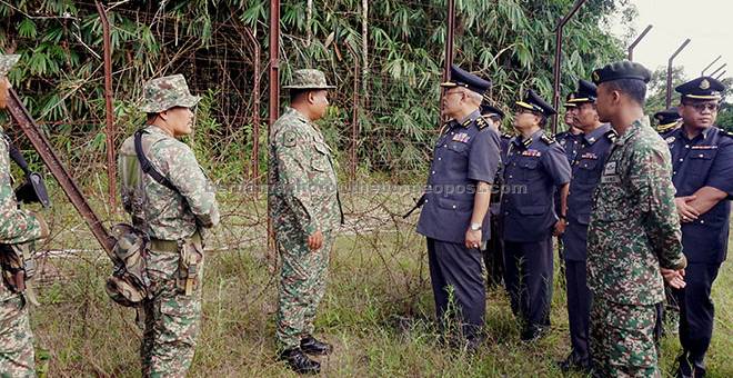 TINJAU: Mohd Roslan (empat kiri) bersama Mohd Zamri (dua kiri) mengadakan lawatan di pagar keselamatan sempadan di Bukit Kayu Hitam semalam. — Gambar Bernama