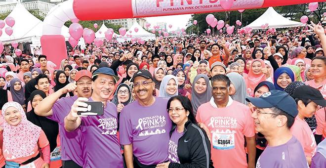 UNTUK ALBUM: Ali dan isteri Puan Sri Rohani Abdullah berswafoto bersama Ketua Pengarah Kesihatan Datuk Dr Noor Hisham Abdullah sebelum melepaskan peserta larian sempena ‘Putrajaya Pink October Run’ di Dataran Putrajaya dekat Putrajaya, semalam. — Gambar Bernama