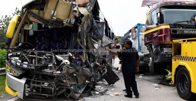 REMUK: Keadaan bas ekspres setelah terbabit dalam kemalangan dengan sebuah lori tangki bahan kimia di KM178.4 Lebuh Raya Utara Selatan (PLUS) menghala utara dekat susur keluar persimpangan Jasin dekat Jasin, semalam. — Gambar Bernama