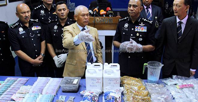 HASIL RAMPASAN: Mohmad Salleh (tengah) menunjukkan sebahagian hasil rampasan dadah, wang dan senjata yang dirampas dalam enam serbuan pada sidang media di Ibu Pejabat Kontinjen Johor Bahru (IPK), semalam. — Gambar Bernama