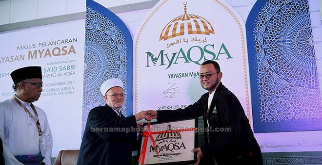 CENDERAHATI: Ekrima menerima cenderahati daripada Noorazman (kanan) selepas melancarkan Yayasan MyAQSA di Masjid Tuanku Mizan Zainal Abidin, Putrajaya, semalam. — Gambar Bernama