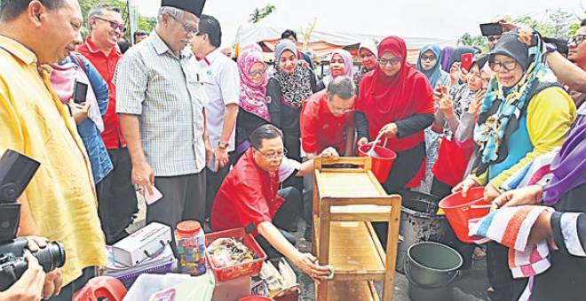 Dato’ Sri Ismail Sabri Yaakob membantu mencuci peralatan rumah mangsa yang terjejas akibat banjir.