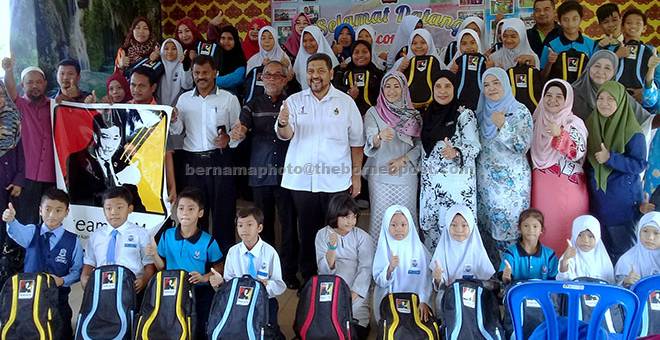 SUMBANGAN: Tun Hairudin bersama murid-murid yang menerima sumbangan bantuan persekolahan kepada murid Sekolah Kebangsaan Port Dickson (SKPD) semalam. — Gambar Bernama