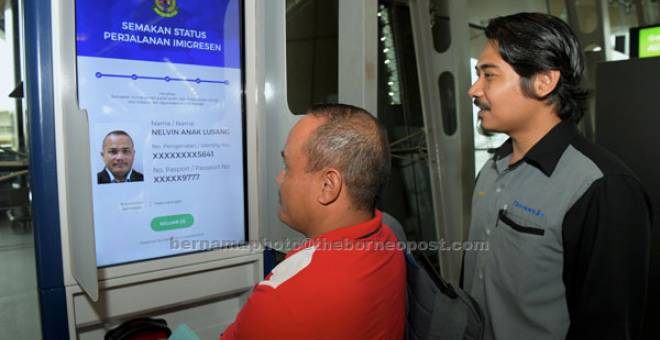 PERIKSA: Penumpang penerbangan Nelvin Lusang memeriksa status senarai hitam pada mesin Kiosk prasemakan senarai hitam atau dikenali sebagai Pre Read Kiosk di ruang legar Balai Perlepasan Lapangan Terbang Antarabangsa Kuala Lumpur (KLIA) di Sepang, semalam. Turut membantu Jurutera Datasonic Smart Solution Sdn Bhd Nik Irwan Nik Azmi (kanan). — Gambar Bernama