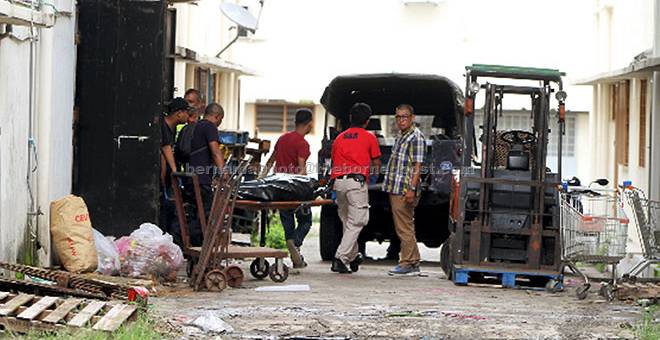 DALAM SIASATAN: Anggota Polis mengangkat mayat seorang pemilik pasar raya yang ditemui mati dengan tangan dan kakinya terikat di premisnya dalam kejadian samun di Pusat Perdagangan Jelapang 2 di Ipoh, semalam. — Gambar Bernama