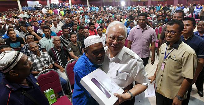 BERTERIMA KASIH: Najib dipeluk penerima Bantuan Rakyat 1Malaysia (BR1M) Harun Abu, 56, sebagai tanda terima kasihnya kepada Najib pada Pelancaran Penyampaian BR1M 2018 Peringkat Kebangsaan di Dewan Konvensyen Sultan Ahmad Shah, Pekan semalam. — Gambar Bernama