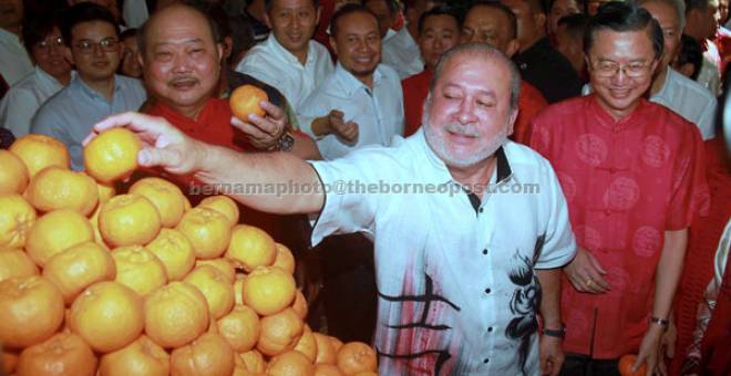 BERSAMA RAKYAT:Sultan Johor Sultan Ibrahim (tengah) bersama Lim (kiri) dan Tee (kanan) mengambil buah limau mandarin untuk diberikan kepada orang ramai pada Majlis Chap Goh Meh anjuran IWHG di Pusat Konvensyen Danga dekat Johor Bahru, semalam. — Gambar Bernama