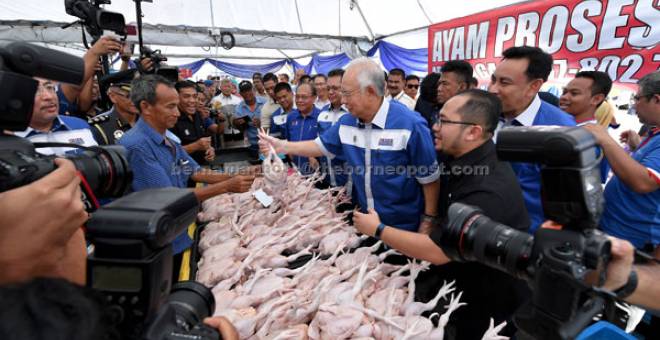 PERCUMA: Najib memberikan ayam yang dijual pada Program Jualan Sentuhan Rakyat 2018 secara percuma kepada rakyat bertuah Mohd Yasin Abdullah di pekarangan Kompleks Sukan Negeri Gong Badak dekat Kuala Nerus, semalam. Turut hadir Menteri Besar Datuk Seri Ahmad Razif Abd Rahman. — Gambar Bernama