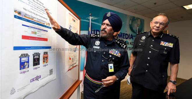 CARA SEMAK: Amar Singh (kiri) menunjukkan poster portal semakan ‘Mule Account’ kepada pemberita pada sidang media mengenai jenayah siber dan pelancaran Operasi Mule Account Siri Satu 2018 di Menara KPJ, Jalan Tun Razak dekat Kuala Lumpur, semalam. — Gambar bernama