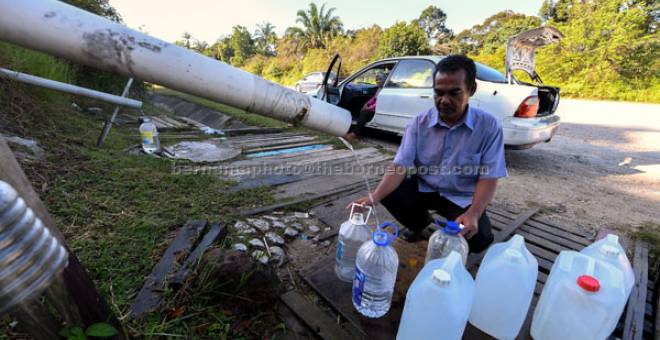 MASALAH AIR:  Basri Bahyar, 55, terpaksa mengambil air bukit di sekitar Jalan Persiaran Mokhtar Dahari di Puncak Alam semalam akibat gangguan bekalan air sejak Selasa lalu. — Gambar Bernama