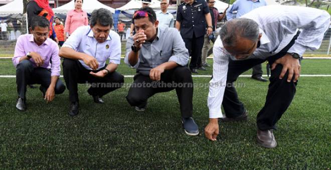 TIJAUAN: Mohamad Hasan (dua, kanan) meneliti kualiti rumput sintetik yang dinaik taraf pada Majlis Perasmian Projek Naik Taraf Padang Bola Sepak Sintetik Rahang di Jalan Zaaba, Rahang semalam. — Gambar Bernama