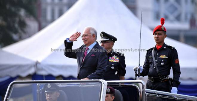 TABIK HORMAT: Najib memberi tabik hormat kepada para pesara polis selepas memeriksa Perbarisan Peringatan Hari Polis ke-211 di Pusat Latihan Polis (Pulapol), Jalan Semarak di ibu negara semalam. Turut hadir Mohamad Fuzi.  — Gambar Bernama