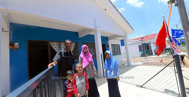 RUMAH BAHARU: Yusri Zainol, 43, dan isteri Suria Md Ariffin, 39, serta tiga anak mereka Nur Balqis Maisarah, 11, Mohd Qayyum, 8, dan Harith Danish, 4, di hadapan rumah baharu mereka di Kampung Nelayan, Tanjung Dawai di Sungai Petani semalam. — Gambar Bernama