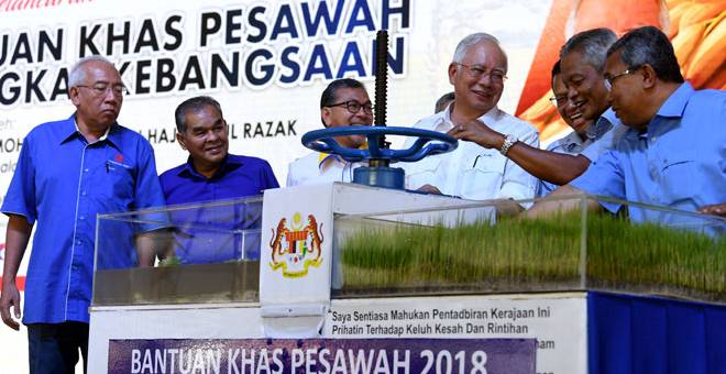 LANCAR: Najib (empat kiri) membuka kunci air sebagai gimik pelancaran bantuan khas pesawah peringkat kebangsaan di Pusat Pertumbuhan Desa Sungai Korok, Alor Biak di Jerlun semalam. — Gambar Bernama