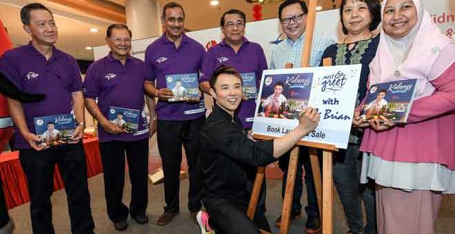 RASMI: Brian menurunkan tandatangan pada plak perasmian Buku Resipi Pesakit Dealisis pada Majlis Sambutan Hari Buah Pinggang Sedunia 2018 anjuran Yayasan Buah Pinggang Kebangsaan (NKF) di ibu negara semalam. Turut bersama Dr Zaki (empat kiri). — Gambar Bernama