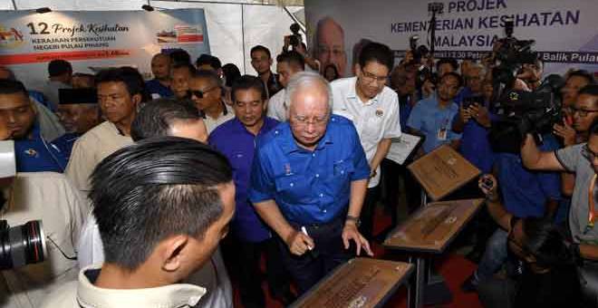 TANDATANGAN: Najib menandatangani satu daripada 12 plak projek Kementerian Kesihatan                     di Pulau Pinang pada Majlis Balik Pulau Bersama Perdana Menteri di Sekolah Menengah Kebangsaan Seri Balik Pulau di Balik Pulau semalam. — Gambar Bernama