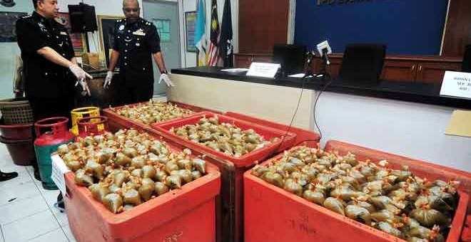 HASIL SERBUAN: A. Anbalagan (dua kiri) menunjukkan bungkusan ketum serta peralatan memproses ketum bernilai RM13,000 ketika sidang media di Ibu Pejabat Polis Daerah Barat Daya dekat Balik Pulau, semalam. — Gambar Bernama