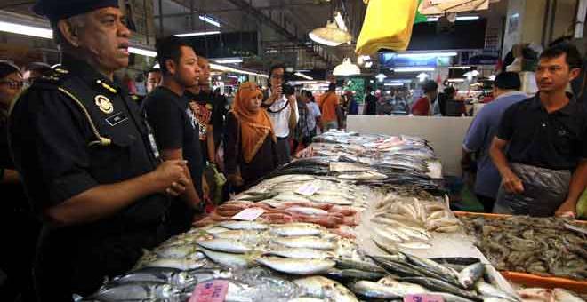 TINJAU: Aris (kiri) meninjau harga ikan ketika menjalankan pemeriksaan di Pasar Awam Larkin, Johor Bahru semalam. — Gambar Bernama