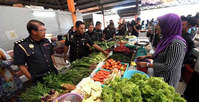 TURUN PADANG: Chin (kiri) mengadakan pemeriksaan harga barangan keperluan harian di Pasar Awam Jitra, Alor Setar semalam. — Gambar Bernama