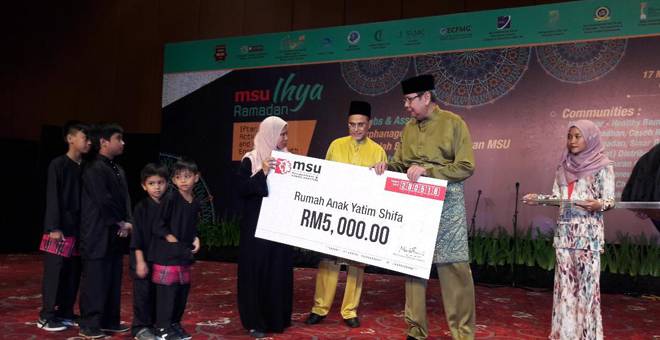ZAKAT: Mohd Syukri menyampaikan sumbangan zakat sebanyak RM5,000 kepada Rumah Anak Yatim Shifa pada Majlis Iftar MSU bersama anak yatim di Shah Alam.
