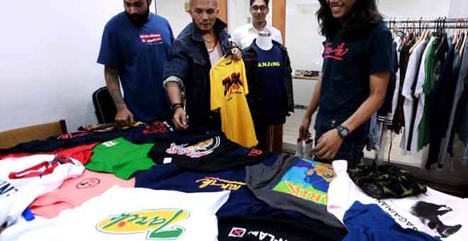 KOLEKSI KELUARAN: Afiq (kanan) bersama tiga rakan kongsinya melihat koleksi kemeja-T keluaran Tarik Jeans di pejabatnya di Petaling Jaya, Kuala Lumpur. — Gambar Bernama