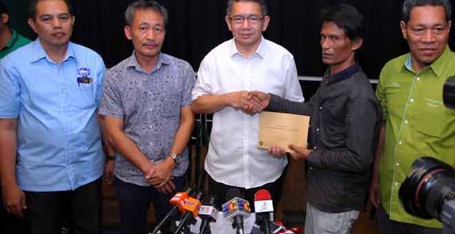 BEBAS: Salahuddin (tengah) menyampaikan sumbangan kepada Kamaruzaman (dua kanan) yang ditahan pihak berkuasa Indonesia sejak April tahun lepas ketika mengadakan pertemuan di Johor Bahru, semalam. — Gambar Bernama