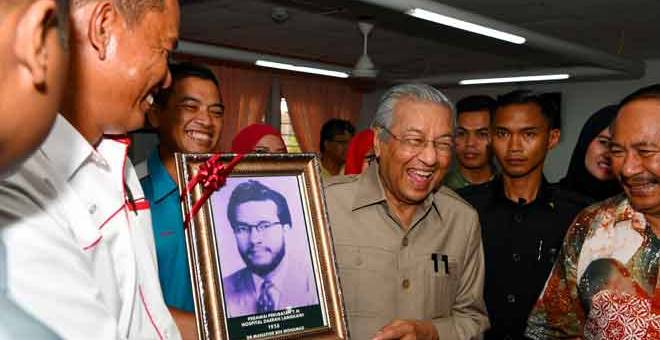 LAWAT: Dr Mahathir tergelak melihat gambar foto lamanya ketika Pengarah Hospital Langkawi, Dr Mansor Ismail menyampaikan gambar fotonya yang pernah berkhidmat di Hospital Langkawi pada 1956 ketika membuat lawatan ke Hospital Langkawi di Langkawi, semalam. — Gambar Bernama