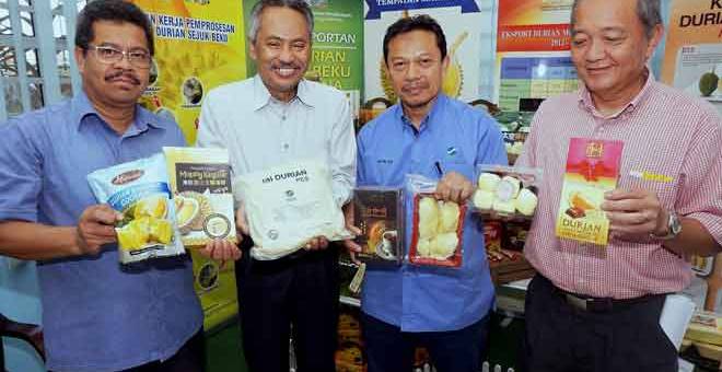 PRODUK DURIAN: Ahmad Ishak (dua kiri) bersama Anuar (kiri) menunjukkan produk-produk yang dihasilkan menggunakan pes durian di pusat pemprosesan dan penyimpanan isi durian sejuk beku di Sungai Petani, semalam. — Gambar Bernama