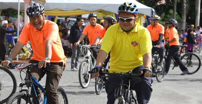 KAYUH BASIKAL: Tuanku Syed Faizuddin (kanan) diiringi Dzulkefly  berkenan menyertai kayuhan basikal sempena Sambutan Hari Malaria Sedunia Peringkat Kebangsaan 2018 di Padang Besar, semalam. — Gambar Bernama