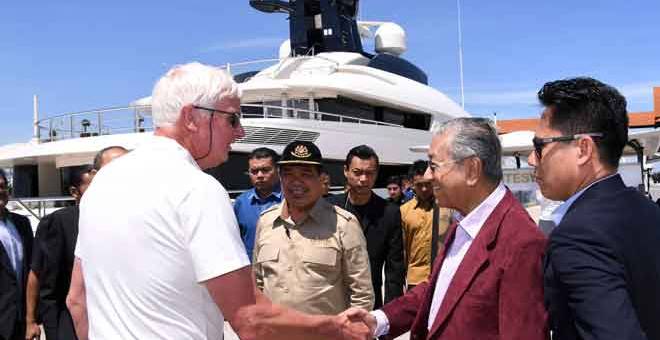 LAWATAN: Tun Dr Mahathir (dua, kanan) disambut oleh Kapten kapal layar mewah Equanimity, Oyastein Senneseth (kiri) ketika melawat kapal itu di Terminal Bousttead Cruise Centre, Pulau Indah, semalam. — Gambar Bernama