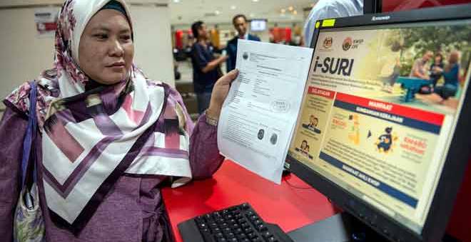 MASA DEPAN TERBELA: Seorang wanita Jamaliah Ismail menunjukkan borang pendaftaran yang telah diluluskan selepas membuat pendaftaran Caruman Sukarela Insentif Suri (i-Suri) di Ibu Pejabat KWSP, Jalan Raja Laut di Kuala Lumpur, semalam. — Gambar Bernama