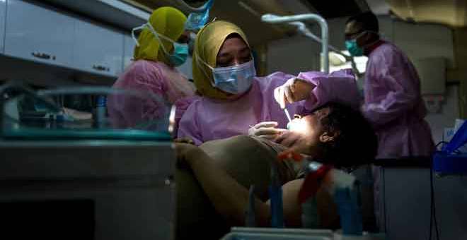 MINGGU SIHAT: Dr Ainun (tengah) memeriksa gigi peserta sempena pelancaran Minggu Promosi Kesihatan Pergigian Kebangsaan 2018 di Dataran Dewan Bandaraya Kuala Lumpur, di Kuala Lumpur semalam. — Gambar Bernama