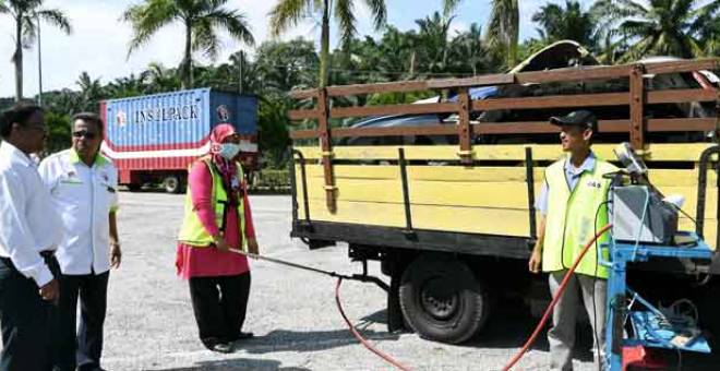 TINJAU: S. Veraapan (kiri) melihat para petugas Jabatan Alam sekitar (JAS) membuat Ujian Pelepasan Asap daripada sebuah lori ketika Operasi Pematuhan Asap Kenderaan Diesel di Rembau, semalam. — Gambar Bernama