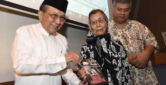 TERIMALAH: Rais (kiri) menyampaikan buku ‘Autobiografi Seorang Pemberontak’ kepada balu Allahyarham Dr Kassim, Sharifah Fawziah (tengah) dan anaknya Ahmad Shauqi Kassim,51 pada majlis pelancaran buku tersebut di Fakulti Sastera dan Sains Sosial, Universiti Malaya, dekat Kuala Lumpur, semalam. — Gambar Bernama