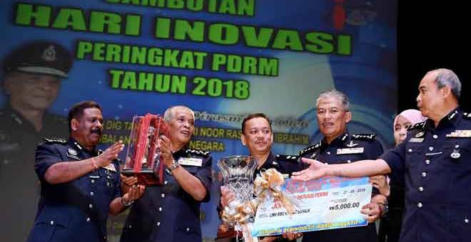 PENYAMPAIAN ANUGERAH: Noor Rashid (dua kiri) menyampaikan Piala Kejohanan Inovasi PDRM 2018 kepada pasukan Kedah yang mencipta Intervensi Pencegahan dan Penyalahgunaan Dadah kepada Pelajar Sekolah pada Program Inovasi PDRM 2018 di Universiti Sains Malaysia (USM), George Town, semalam. — Gambar Bernama