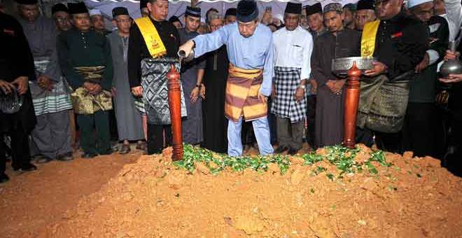 BERSEMADI: Sultan Sharafuddin menyiram air mawar di atas pusara Hassan selepas selesai pengebumian di Makam Diraja Shah Alam, Shah Alam semalam. — Gambar Bernama