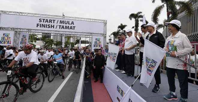 SEDIA MULA: Dr Mahathir (dua kanan) dan isteri Dr Siti Hasmah (kanan) melepaskan para peserta ‘fun ride’ pada Hari Sukan Negara di Bandar Sukan Bukit Jalil dekat Kuala Lumpur, semalam. Turut kelihatan Syed Saddiq (tiga kanan) dan Menteri Luar Datuk Saifuddin Abdullah (empat kanan). — Gambar Bernama