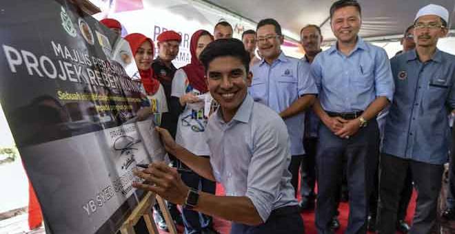 PERASMIAN: Saddiq menandatangan simbolik perasmian Program Bersama Belia Penghuni Penjara Sungai Buloh dan Pelancaran Projek Reben Kuning di Sungai Buloh, semalam. — Gambar Bernama