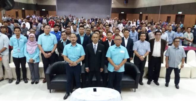 Farrin (tengah) merakamkan gambar bersama peserta forum di CIDB Kuching hari ini. Turut kelihatan Pengarah CIDB Sarawak, Mohd Merzan Hashim (kanan).