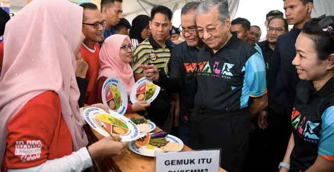 LAWATAN: Dr Mahathir (dua kanan) melawat ruang pameran pemakanan seimbang selepas melancarkan Kempen Gaya Hidup Aktif (WALK) 2018 di Setia Alam dekat Shah Alam, semalam. Turut hadir Menteri Kesihatan Datuk Seri Dr Dzulkefly Ahmad (tiga kanan). — Gambar Bernama