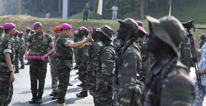 MAJLIS PENUTUPAN: Ahmad Kamarulzaman ketika memakaikan beret Ungu kepada 65 penuntut Kursus Asas Komando PASKAL Siri 65/18 pada majlis penutup dan Upacara Perasmian Pusat Latihan Pasukan Khas Laut (PASKAL) di Pangkalan TLDM, Lumut, semalam. — Gambar Bernama