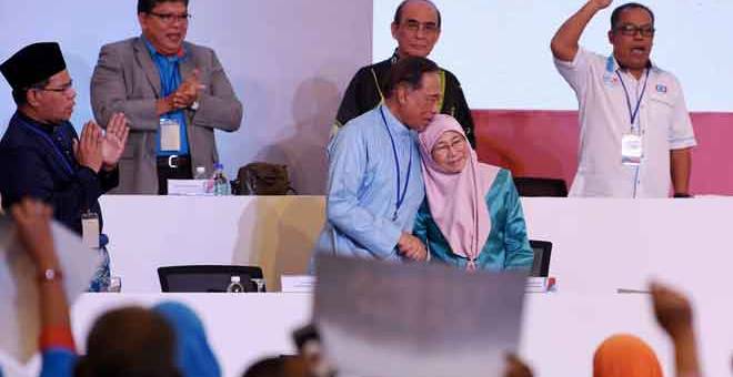 PERJUANGAN BELUM SELESAI: Dr Wan Azizah bersama suaminya Anwar selepas menyampaikan ucapan dasar dan merasmikan  Kongres Nasional Keadilan ke-13 di Pusat Konvensyen Ideal (IDCC) Shah Alam semalam. — Gambar Bernama 