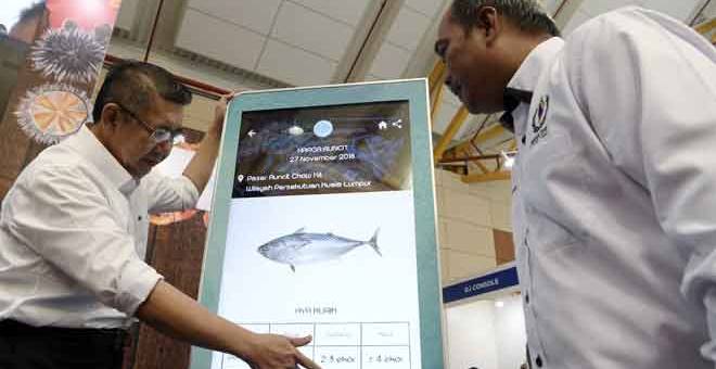 SIMBOLIK: Salahuddin (kiri) melihat harga runcit ikan tongkol selepas melancarkan portal Risikan Harga Ikan Lembaga Kemajuan Ikan Malaysia sempena Pameran Pertanian, Hortikultur dan Agro Pelancongan Antarabangsa (MAHA) 2018 di Taman Ekspo Pertanian Malaysia (MAEPS) Serdang semalam. — Gambar Bernama