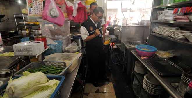 KOTOR: Dr Wan Mansor melakukan pemeriksaan di kawasan dapur salah sebuah restoran                          di Butterworth ketika Operasi Sihat Bil 10/2018 di Butterworth semalam. — Gambar Bernama