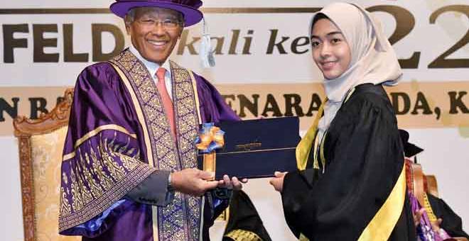 TAHNIAH: Megat Zaharuddin (kiri) menyampaikan sijil kepada pelajar cemerlang Nur Athira           Azeera Mamat di Menara FELDA di Kuala Lumpur semalam. — Gambar Bernama