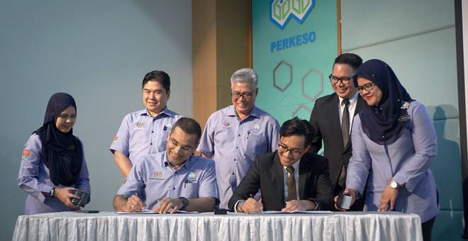 PERJANJIAN: Mohammed Azman (duduk, kiri) bersama Timbalan Presiden MyDrebar Shahrul Anuar Zamri (duduk, kanan) menandatangani dokumen perjanjian persefahaman pada pelancaran MyDrebar serta majlis menandatangani perjanjian persefahaman antara PERKESO dan MyDrebar di Wisma PERKESO dekat Kuala Lumpur, semalam. — Gambar Bernama